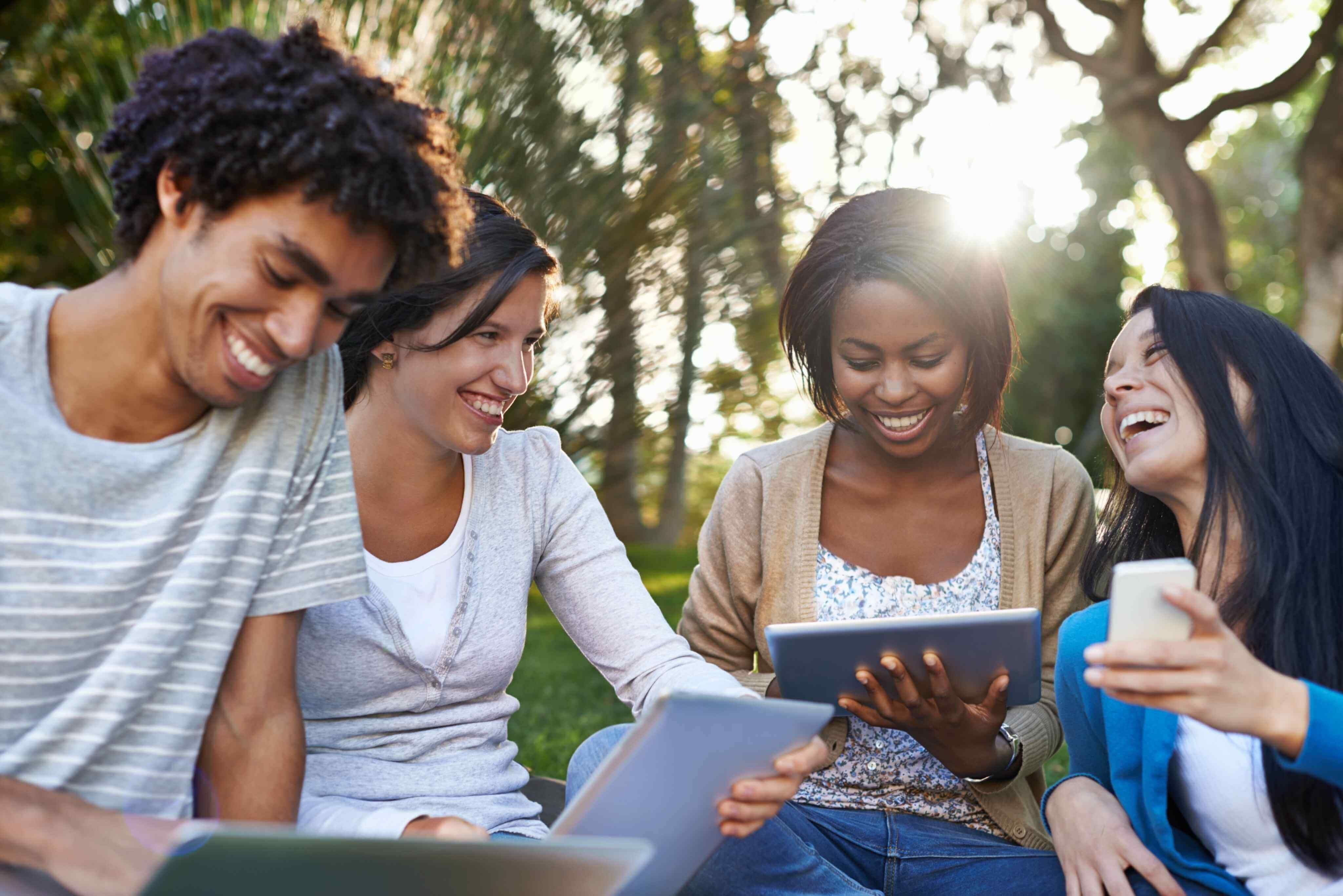 A group of friends are having a picnic and laughing together.